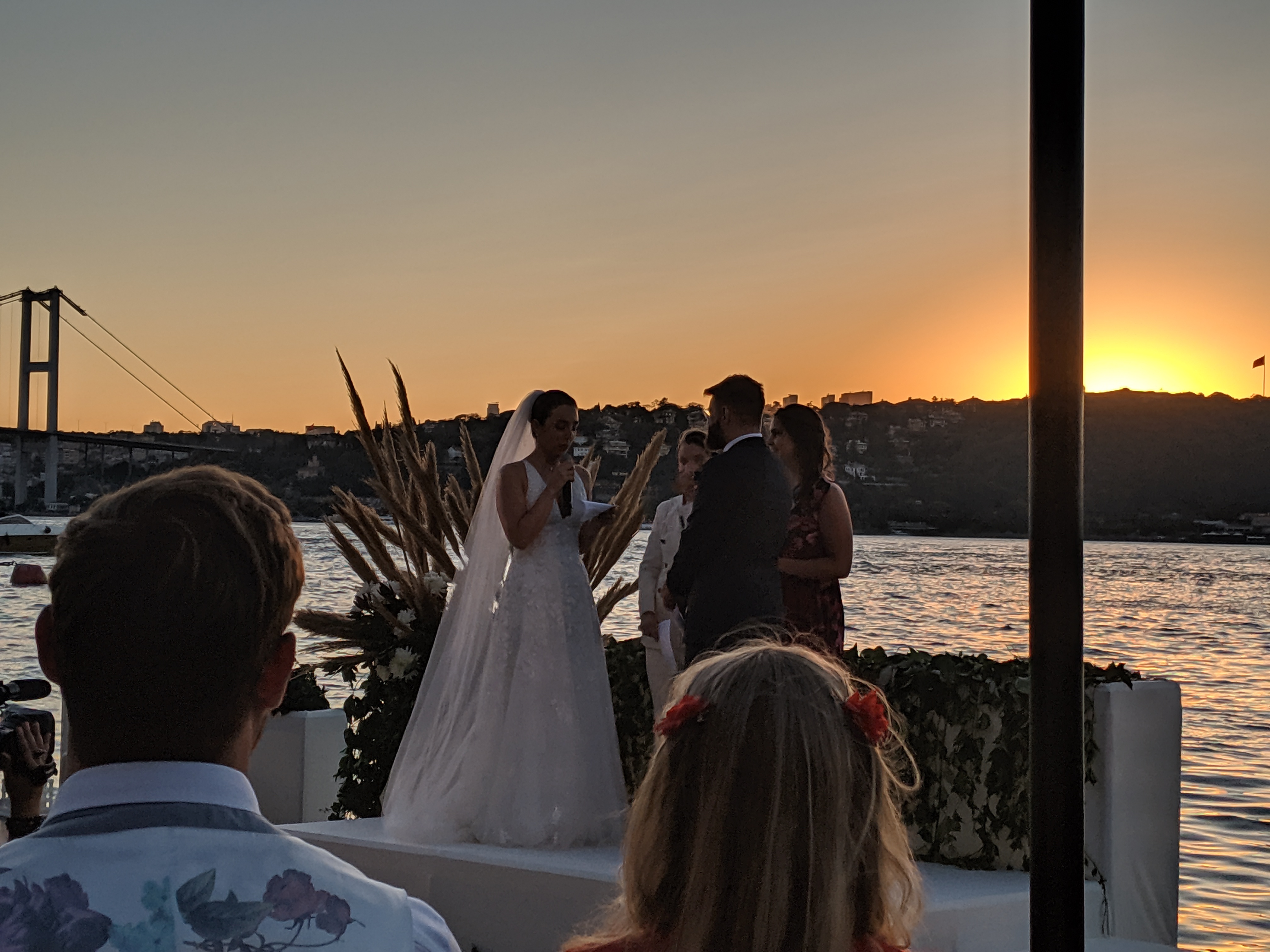 Wedding ceremony at sunset with the Bosphorus Bridge and Istanbul skyline silhouetted in the background