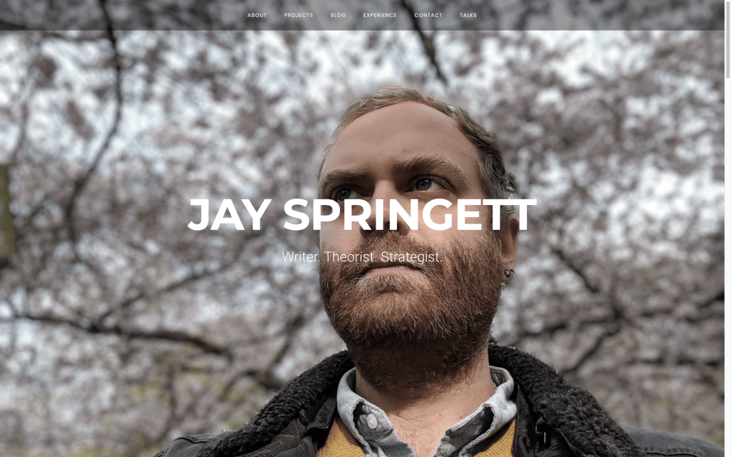 Screenshot of thejaymo.net homepage showing Jay Springett's portrait photo with the text "Jay Springett – Writer. Theorist. Strategist."