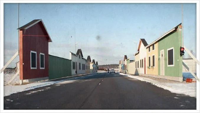 Snowy street with colorful painted houses in red, green, yellow, and white with snow covering the ground