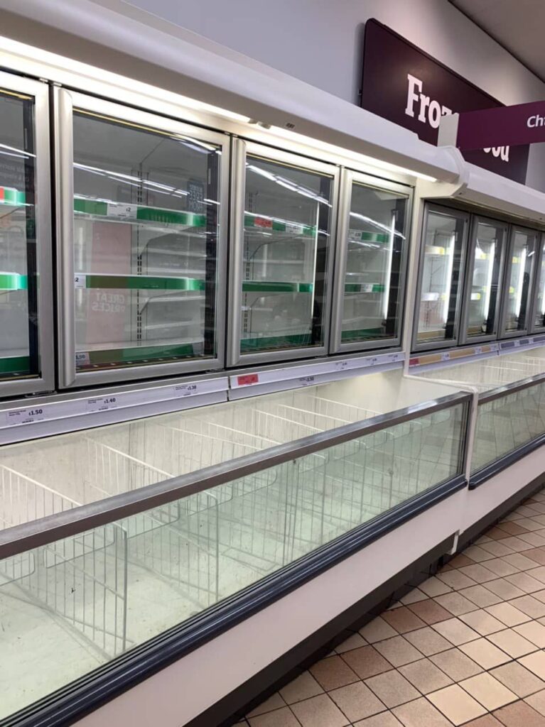 Empty refrigerated display cases in supermarket during pandemic lockdown stockouts