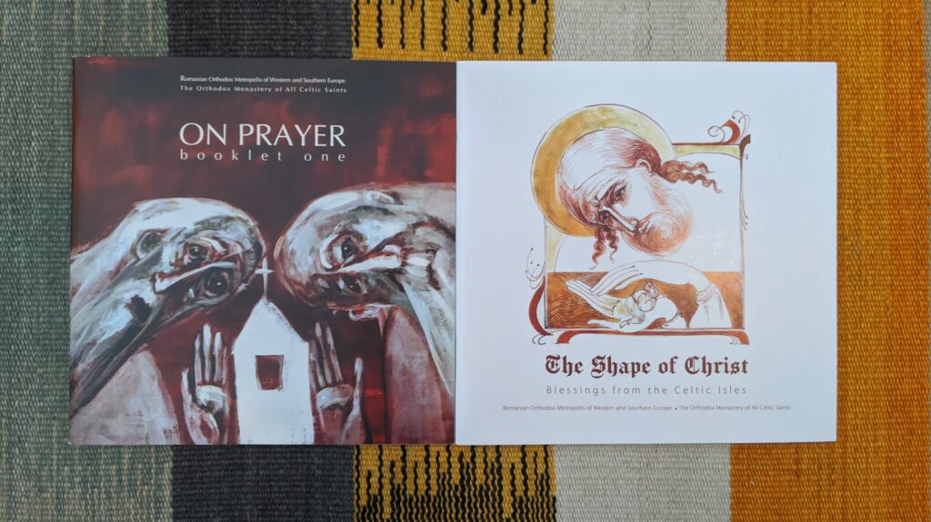 Two religious book covers displayed on colorful woven fabric with yellow, green, and orange stripes