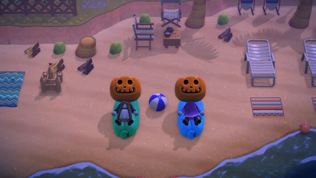 Animal Crossing screenshot of Halloween-themed characters with jack-o'-lantern heads in beach scene