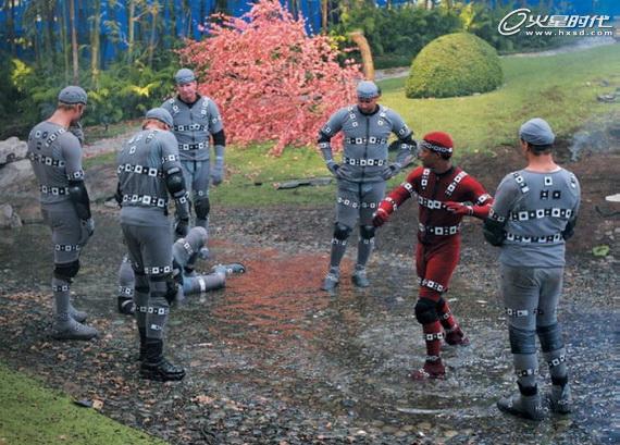 Group of people in tactical gear running through a field with a red flowering tree in the background