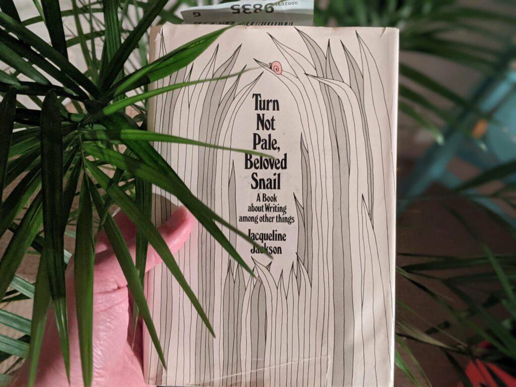 Book cover "Turn Not Pale, Beloved Snail" by Jacqueline Jackson with spider plant in foreground