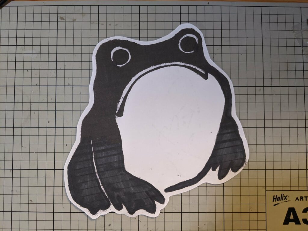 Sad frog sticker with purple border on graph paper background