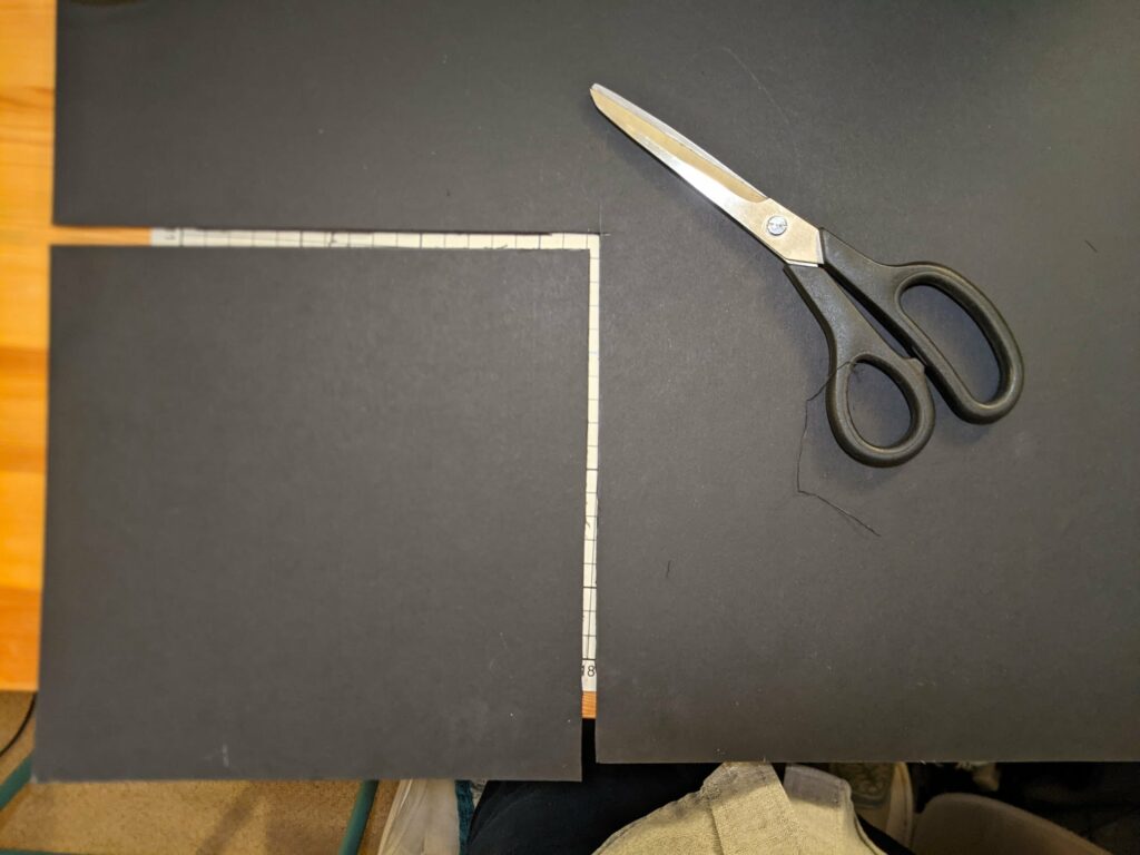 Pair of scissors on dark chalkboard with orange-yellow background