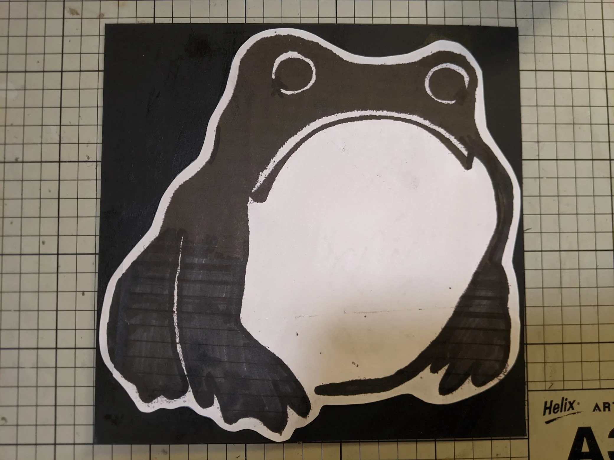 Hand-drawn black and white frog illustration on graph paper