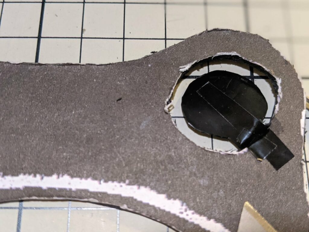 Dark gray puppet fabric with white-outlined circular hole and black rod inserted through it
