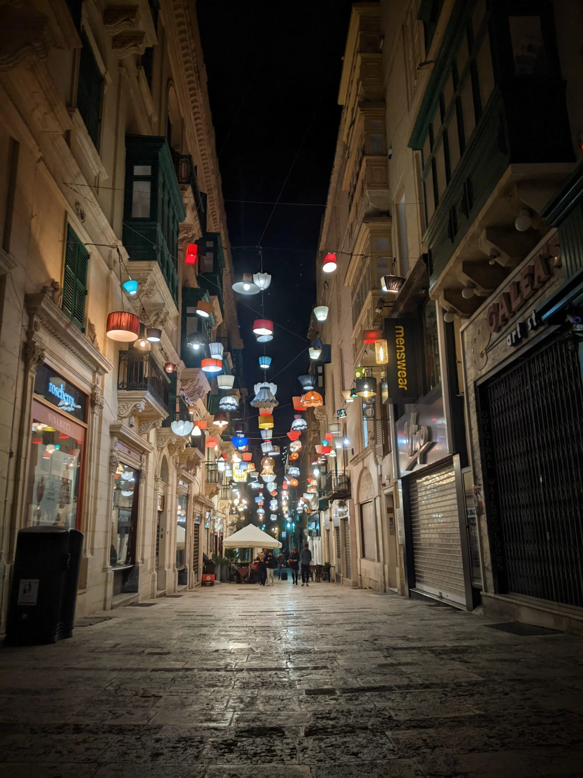 Pedestrian shopping street at night with colorful decorative paper lanterns overhead