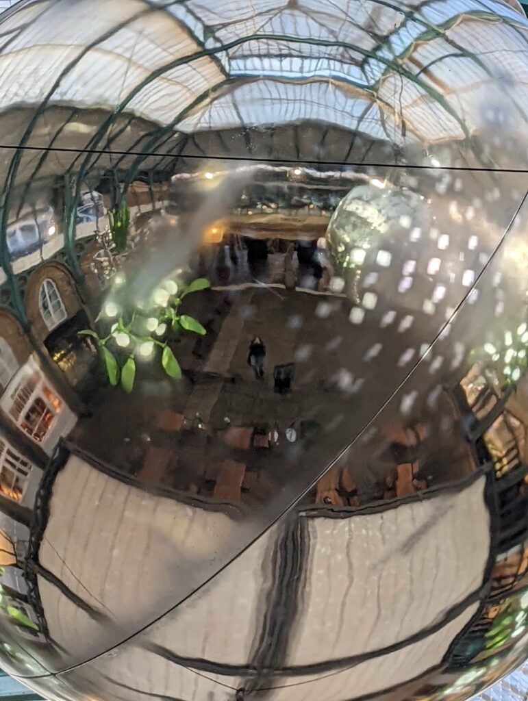 Night photo of covered market arcade with glass ceiling, warm lights and bokeh creating dreamy atmosphere