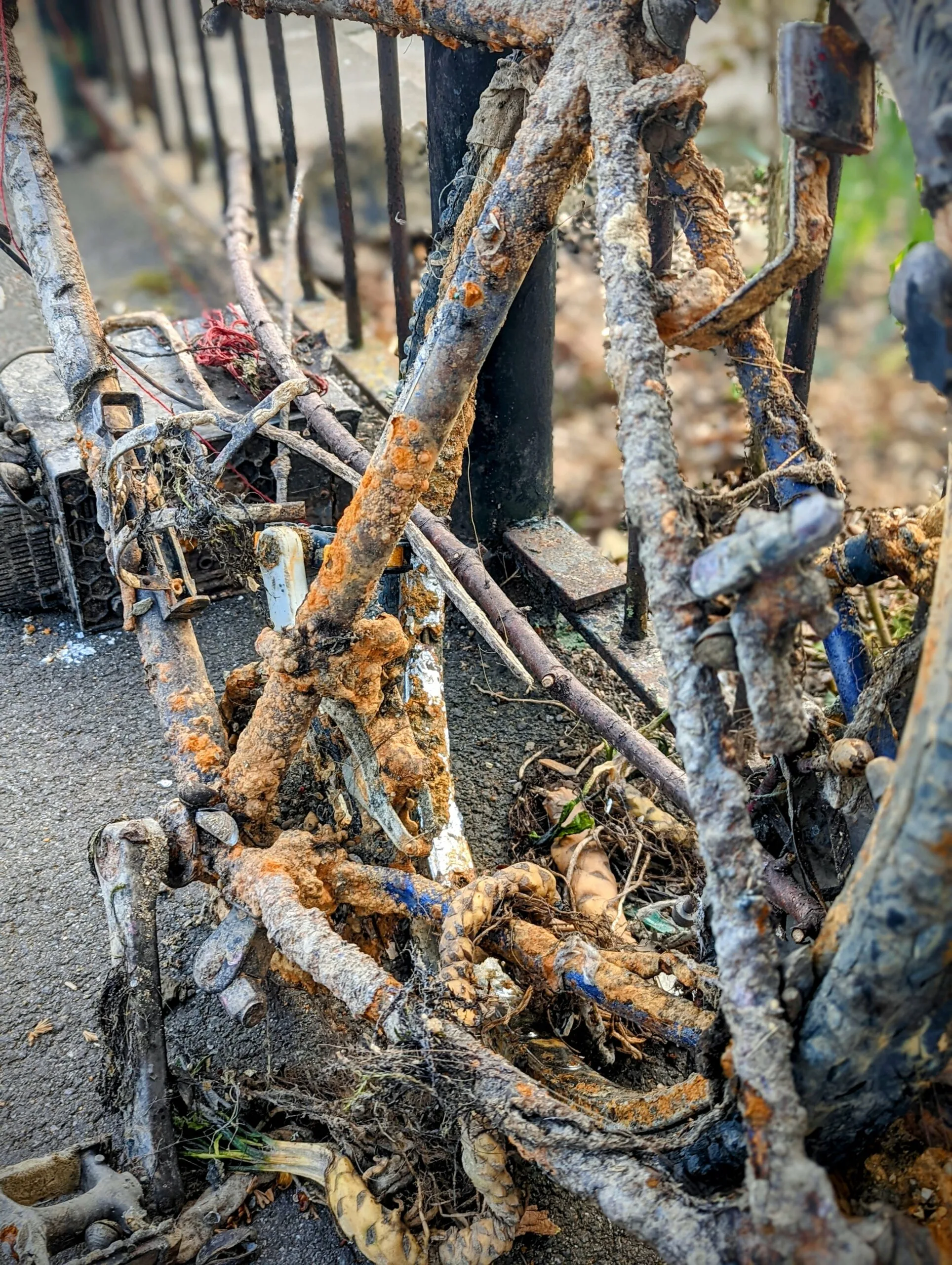 Close-up of rusty chains and metal machinery on metal fence