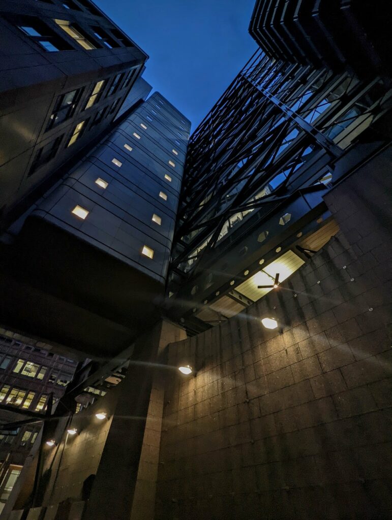 Upward looking shot of modern buildings at twilight with lit windows and blue sky