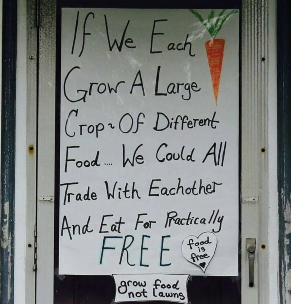 Handwritten sign on a door: If we each grow a large crop of different food... we could all trade and eat for free. Bottom text: grow food not lawns.