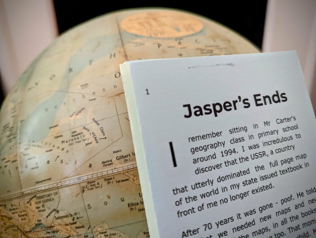 A vintage globe showing the Marshall Islands behind a page titled Jasper's Ends, which mentions a geography class in 1994.