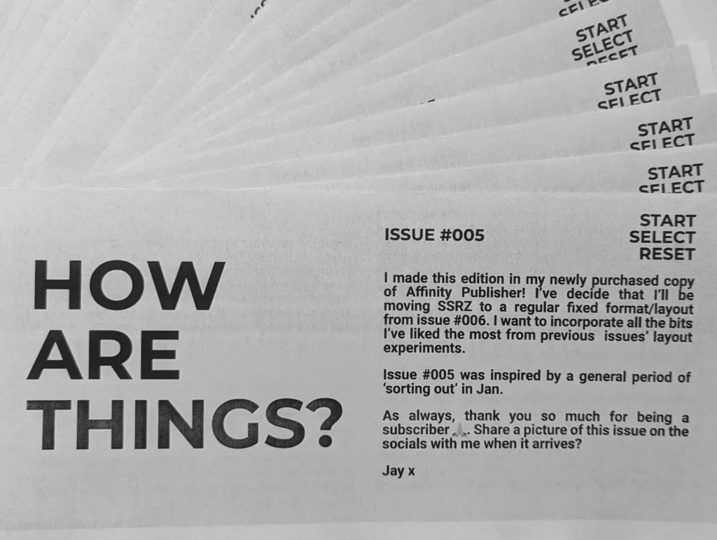 Fanned stack of black and white zines titled "HOW ARE THINGS? ISSUE #005" with a personal note and Start, Select, and Reset labels.