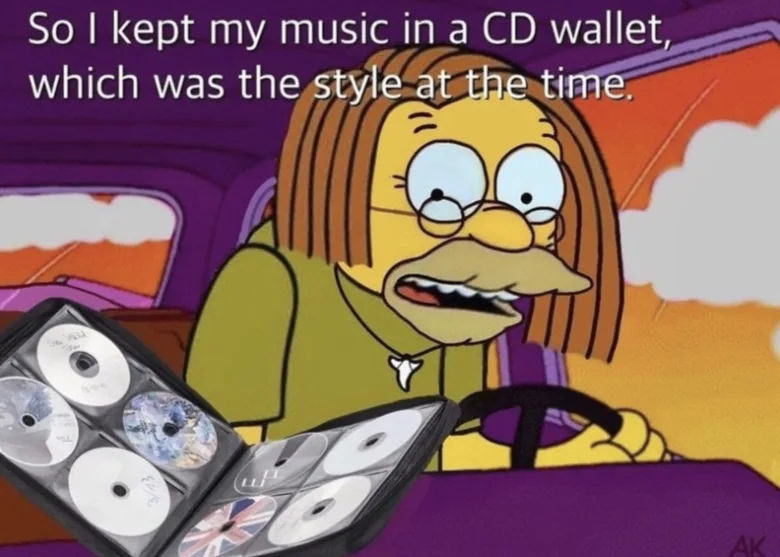 Featured image for CD Wallet - Grampa Simpson with long hair driving and looking at a CD wallet. Text: So I kept my music in a CD wallet, which was the style at the time.