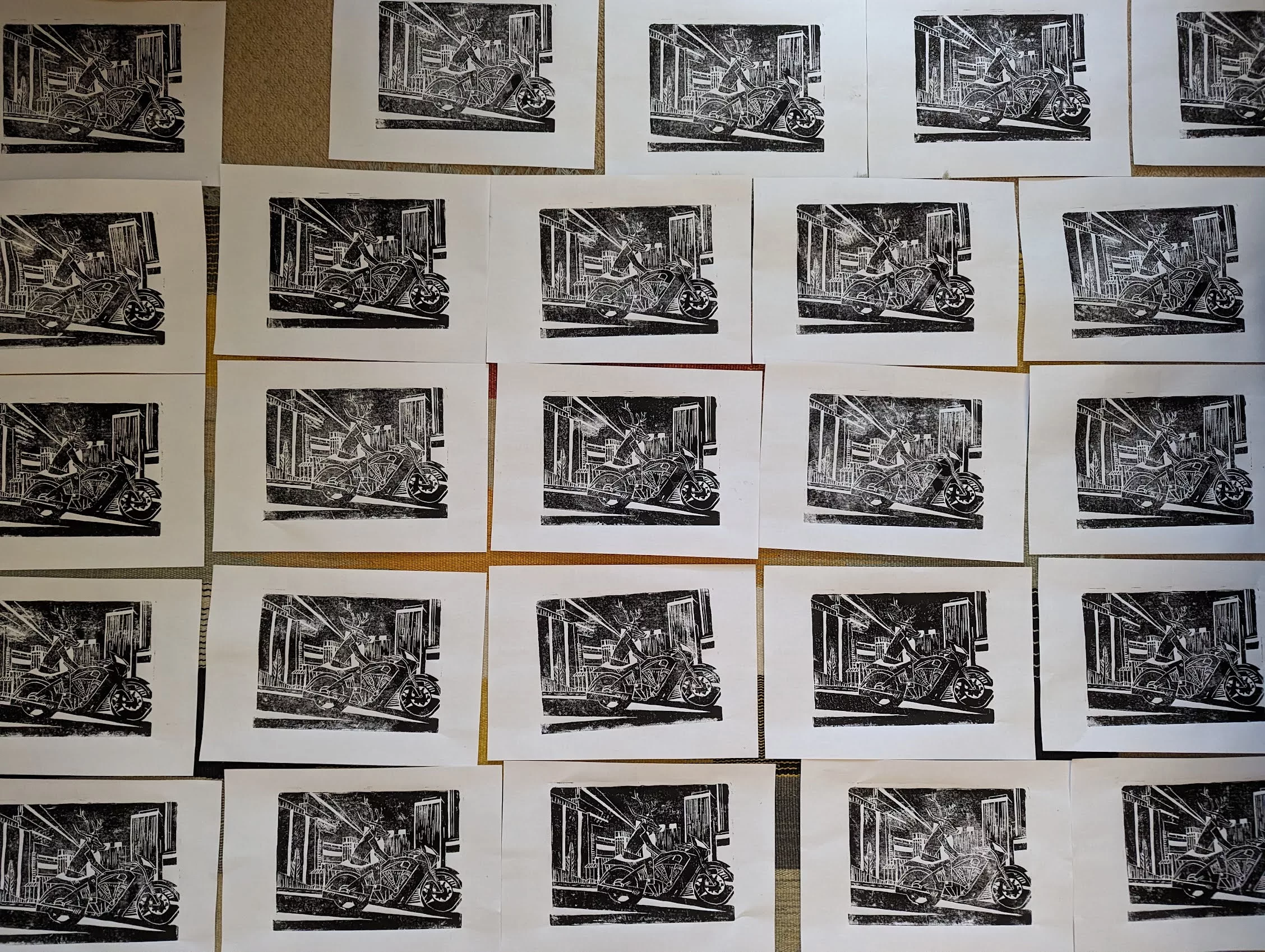 Grid of black and white linocut prints depicting a deer-headed figure riding a motorcycle through a stylized city at night.