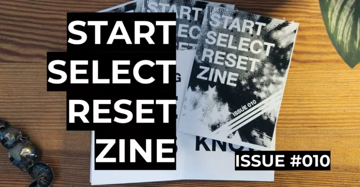 Featured image for Start Select Reset Zine Issue 010 - A stack of printed zines on a wooden table with large black and white title text.