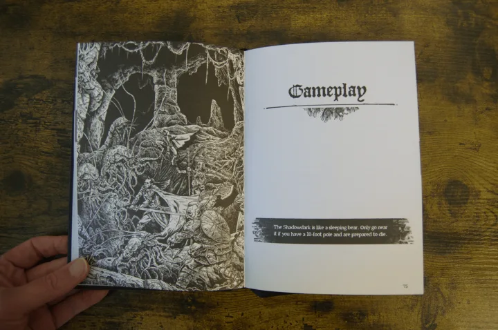 Shadowdark RPG rulebook open to the Gameplay section, featuring a detailed black and white ink illustration of a dungeon battle in a cave.