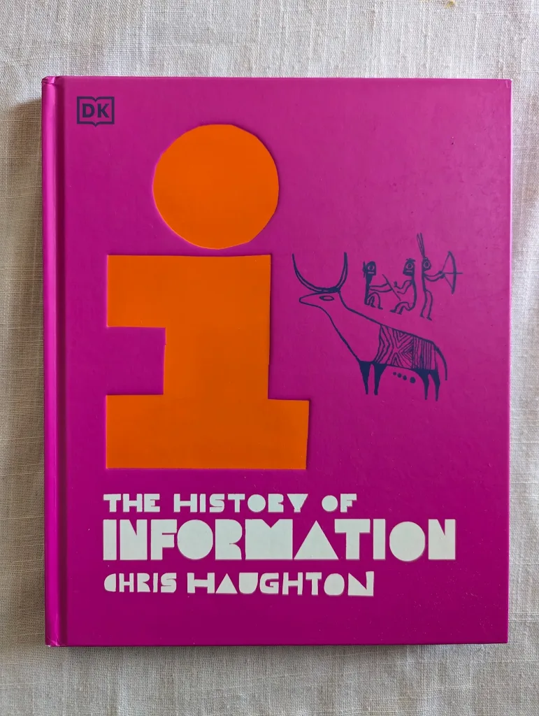 Pink book cover of The History of Information by Chris Haughton featuring a large orange lowercase 'i' and blue line drawings of cave art.