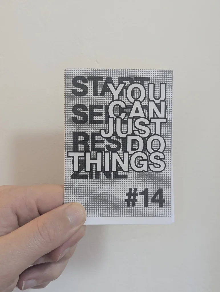 A hand holds a zine with overlapping typography reading YOU CAN JUST DO THINGS and STAY SECRET RES ZINE #14 on a halftone patterned cover.